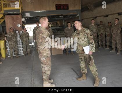 Le sergent-chef en chef. Shawn Drinkard, chef du commandement de l'Air Forces Central Command des États-Unis, présente une de ses pièces pour défi d'un membre de la 1re classe Spradling Ty, 407e Escadron de génie civil expéditionnaire compagnon structurels, au cours d'une visite à un endroit tenu secret en Asie du Sud-Ouest, le 19 novembre 2018. Spradling a été reconnu pour son travail acharné de la lutte contre les inondations récentes. Banque D'Images