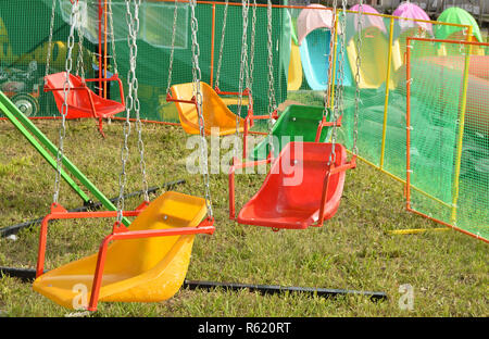 Manèges excitants pour les enfants - balançoires, rond-point sur les chaînes Banque D'Images