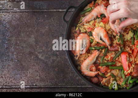 Crevettes, riz, haricots et piments rouges dans une poêle en fonte Banque D'Images