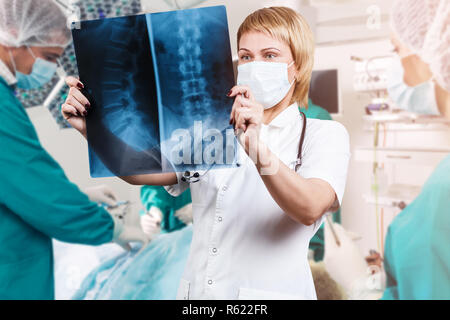 Femme médecin à à une radiographie de la colonne vertébrale. Banque D'Images