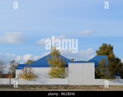 L'immeuble avec garage et bleu métal-plastique en toiture en tôle ondulée. Banque D'Images