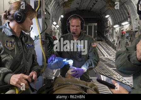 Réserve de l'Armée de l'air Lieutenant-colonel David Ferguson et Tech. Le Sgt. Brigid Dye effectuer des soins médicaux à un patient simulé sur un C-17 Globemaster III au cours d'un exercice de préparation opérationnelle près de Charleston, S.C., le 17 novembre 2018. L'exercice a fait de la 315e Groupe des opérations dans la formation pratique dans une variété de moyens de transport aérien et l'évacuation aéromédicale de tactique dans les événements de combat simulé. Ferguson et le colorant sont attribués au 315e Escadron d'évacuation aéromédicale. Banque D'Images