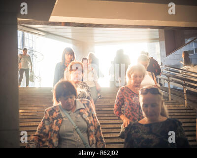 Moscou, Russie - septembre 6, 2018 : Les gens monter et descendre à la station de métro souterrain à l'heure de pointe. Les gens vont jusqu'à la bretelle. Silhouettes de personnes marchant dans les étapes contre la toile du soleil. Banque D'Images