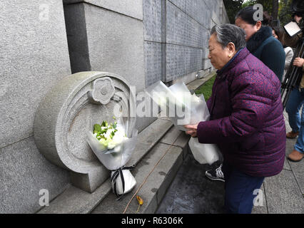 (181203) -- SHANGHAI, le 3 décembre 2018 (Xinhua) -- de survivant le massacre de Nanjing Shi Xiuying, 92, établit les fleurs avant memorial hall mur où les noms des victimes sont gravés au cours de ses activités de commémoration à Nanjing, capitale de la province de Jiangsu, Chine orientale, le 3 décembre 2018. Le massacre de Nanjing a eu lieu lorsque les troupes japonaises ont pris la ville le 13 décembre, 1937. Plus de six semaines, ils ont tué 300 000 civils chinois et soldats sans armes. En février 2014, l'assemblée législative de la Chine haut désigné le 13 décembre comme le Jour commémoratif national pour les victimes de la massacre de Nanjing. À partir de lundi, la famille mem Banque D'Images