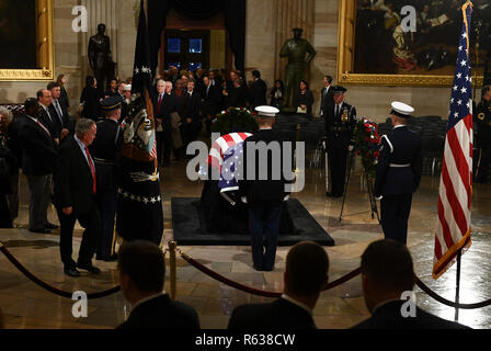 Les gens paient leurs égards près du cercueil recouvert du drapeau de l'ancien président George H. W. Bush dans la rotonde du Capitole à Washington, DC, le 3 décembre 2018. - Le corps de l'ancien président George H. W. Bush se rendra à partir de Houston à Washington, où il résidera dans la région à l'US Capitol au mercredi matin. Bush, qui est mort le 30 novembre, sera de retour à Houston pour son enterrement jeudi. (Photo par Brendan Smialowski/Piscine/AFP) | conditions dans le monde entier Banque D'Images