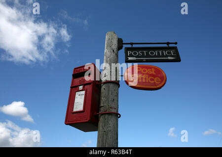 Un bureau de poste à distance postbox avec signes contre un ciel bleu en milieu rural Scotland UK Banque D'Images