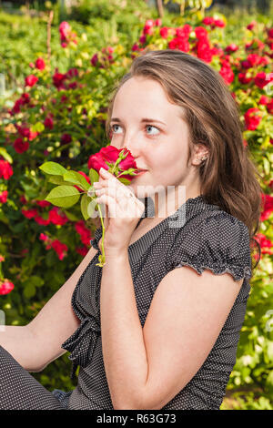 La jeune fille avec une rose dans le jardin Banque D'Images