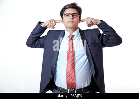 Jeune homme d'affaires indien couvrant les oreilles Banque D'Images