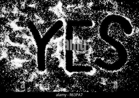 Oui symbole word dessin de doigt sur la neige blanche en poudre sel sur fond noir. Les lettres majuscules Banque D'Images