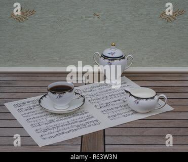 Tasse avec soucoupe anglais, crème verseuse et sucrier, céramique fine porcelaine, sur une feuille de musique Banque D'Images