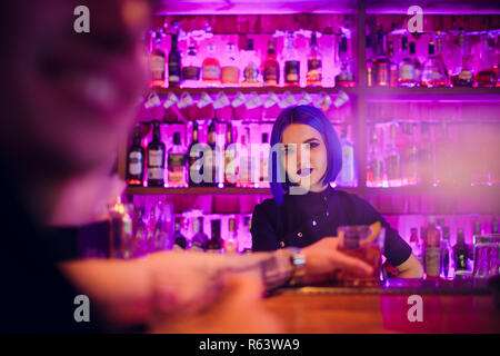 Female bartender. fille avec des cheveux bleus. En cocktail bar de nuit Banque D'Images