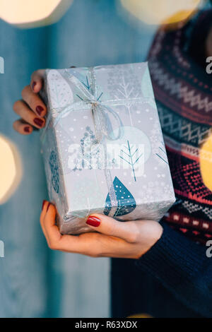 Girl holding a Christmas present Banque D'Images