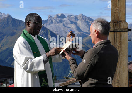 Cérémonie religieuse sur la montagne au-dessus de la ville de Schruns Hochfirst dans la vallée de Montafon avec un prêtre de l'Ouganda Banque D'Images