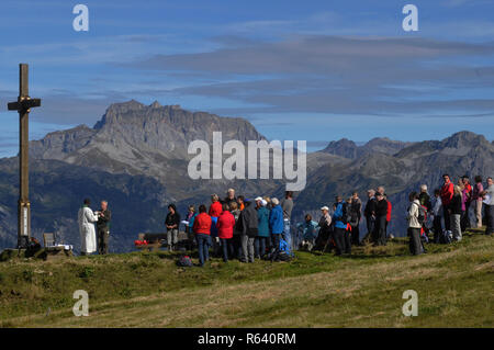 Cérémonie religieuse sur la montagne au-dessus de la ville de Schruns Hochfirst dans la vallée de Montafon avec un prêtre de l'Ouganda Banque D'Images