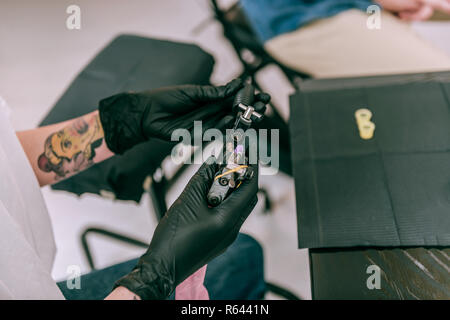 Maître de tatouage/tattoo machine comptable dans les deux mains Banque D'Images