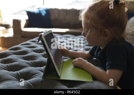 Girl using digital tablet in living room à la maison