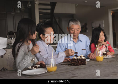 Les grands-parents et les petites-filles ayant du gâteau d'anniversaire Banque D'Images