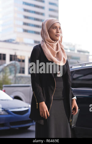 Hijab woman walking in city street Banque D'Images