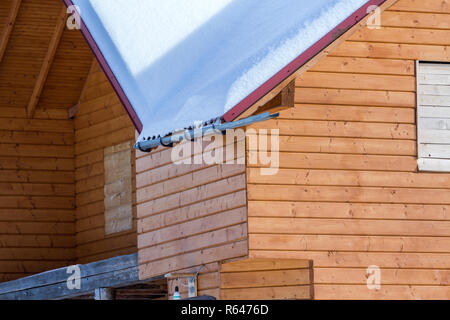 Détail de nouveau gîte traditionnel en bois naturel écologique des matériaux de bois avec toit raide couverte de neige aux beaux jours d'hiver. Les vieilles traditions Banque D'Images