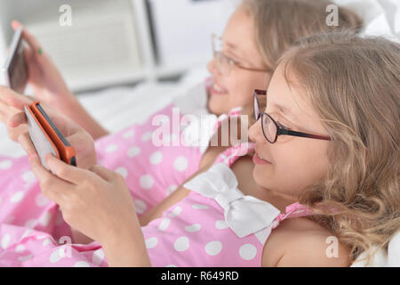 Portrait de deux sœurs jumelles using smartphones Banque D'Images