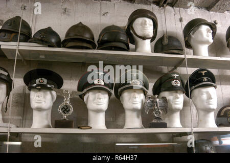 WW11 casques de l'armée allemande et les bouchons sur l'affichage à l'intérieur de la batterei Todt, un bunker en béton massif près de Audresselles sur le littoral Calais/ Boulogne roa Banque D'Images