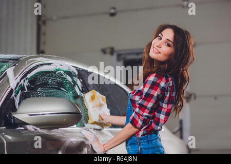 Lavage de voiture en plein air avec une éponge jaune. Belle fille voiture lavage Banque D'Images