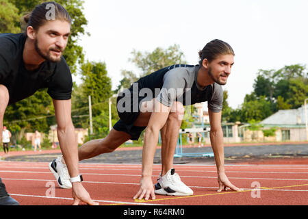 Photo de deux jeunes frères jumeaux sportifs prêts à fonctionner à l'extérieur. Banque D'Images