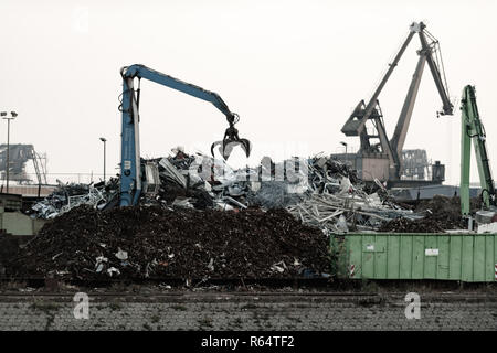 Une grue avec grappins en action sur le chantier de recyclage. Banque D'Images