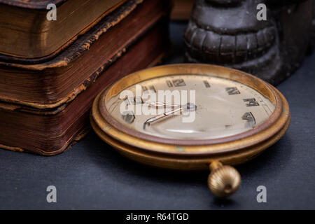 Panta rhei concept : montre de poche antique et la pile de livres à couverture rigide vintage sur fond de pierre naturelle. Banque D'Images