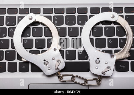 Les menottes sur clavier d'ordinateur portable Banque D'Images