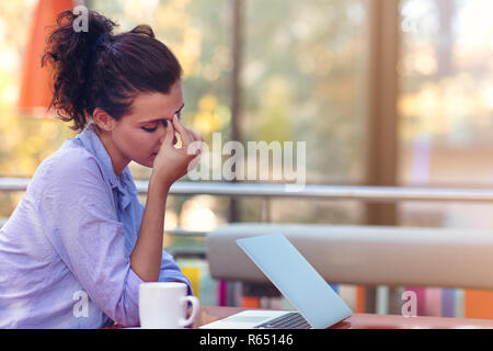Souligné hipster businesswoman working on laptop dans son bureau Banque D'Images