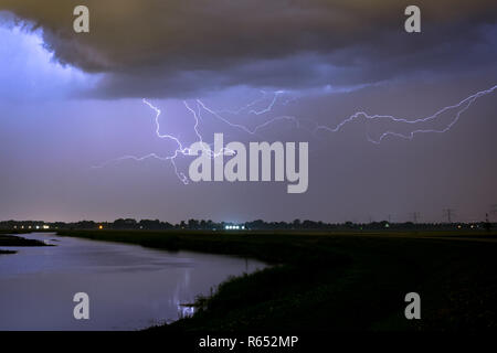 Les éclairs dans le ciel au-dessus d'un lac aux environs de Rotterdam, aux Pays-Bas. Photographié pendant un orage d'été. Banque D'Images