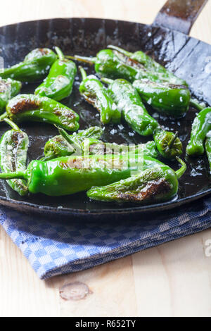 Pimientos de padron dans une poêle de fer Banque D'Images