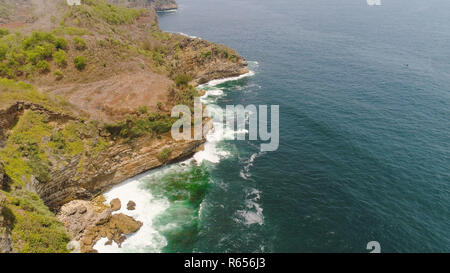 Vue aérienne, bordée de falaises Océan surf avec des vagues dans l'autre. seascape vagues casser sur côte rocheuse de l'île de Java en Indonésie Banque D'Images