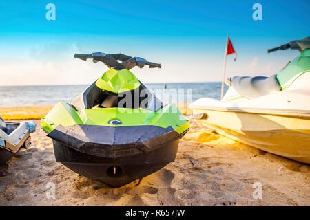 Vue de face d'un jet ski vert garé sur une plage de sable blanc de la plage des Caraïbes sur la Riviera Maya, disponibles à la location pour les sports d'eau sur l'océan Banque D'Images