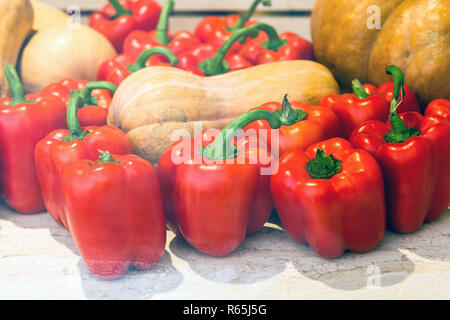 Tas de petits piments rouges parmi les melons Banque D'Images