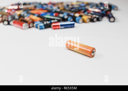 Concept de recyclage. Batterie alcaline se trouve sur le tableau à l'arrière-plan flou des piles alcalines dans l'arrière-plan. copier l'espace. Banque D'Images