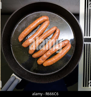 Vue de dessus de saucisses frites merquez dans une casserole sur la cuisinière Banque D'Images