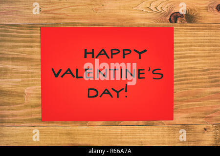 Papier rouge avec un message pour la Saint-Valentin sur table en bois. Banque D'Images