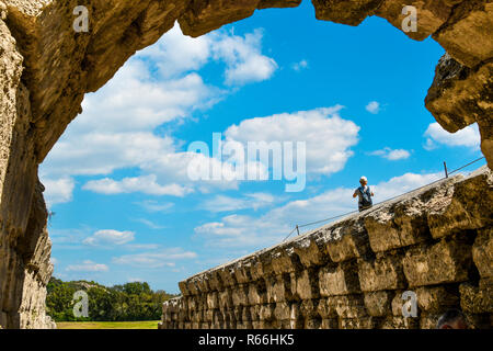 Une femelle vu touristique d'une ancienne arche en pierre donne sur le stade antique dans la ville d'Olympie, Grèce. Banque D'Images