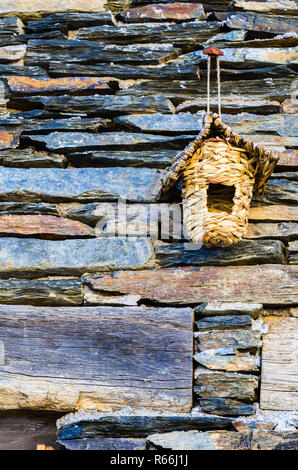 Nid artificiel en osier sur la façade d'une maison d'ardoise Banque D'Images