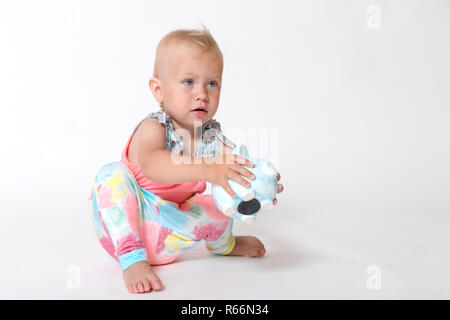 Bébé fille joue avec une épargne piggy bank Banque D'Images