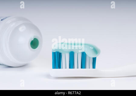 Une brosse à dents et un tube de dentifrice sur une surface blanche Banque D'Images