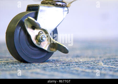 Les petites roues de caoutchouc noir sur le tapis. Banque D'Images