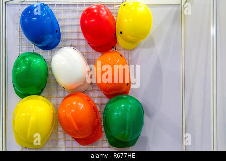 Casque multicolores suspendues sur le mur. Banque D'Images