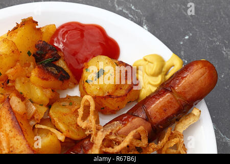 Close up partie des pommes de terre rôties avec saucisse Banque D'Images