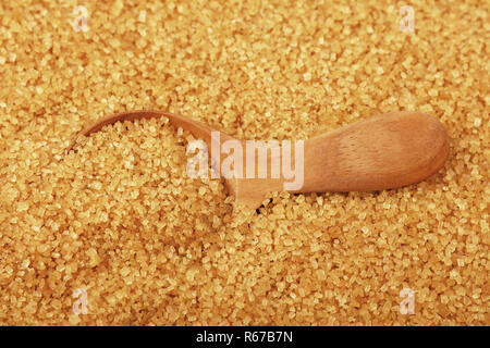 Cuillère en bois Close up scoop en sucre de canne brun Banque D'Images