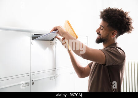 Mettre l'homme de lettres dans la boîte aux lettres Banque D'Images