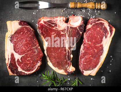 Le bœuf vieilli à sec - steaks de contre-filet, faux-filet, t-bone steaks sur noir Banque D'Images