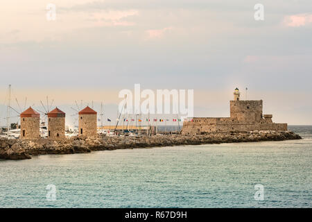 Les moulins à vent et le phare de Le port de Mandraki, Rhodes, Grèce. Banque D'Images